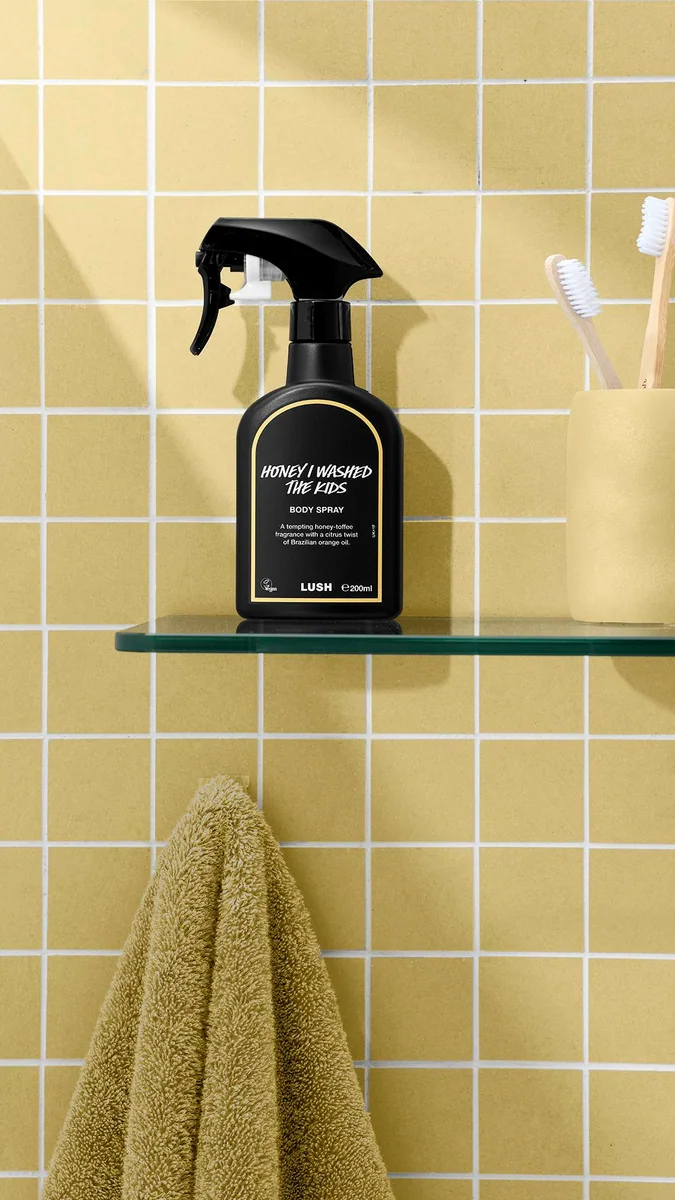Honey I Washed The Kids body spray. A black spray bottle of Lush "Honey I Washed The Kids" Body Spray with a bright yellow banded border label.